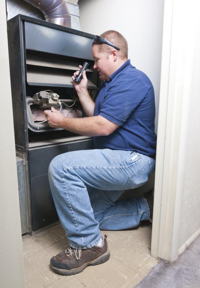 Our service technician in the midst of a heating repair near New Orleans